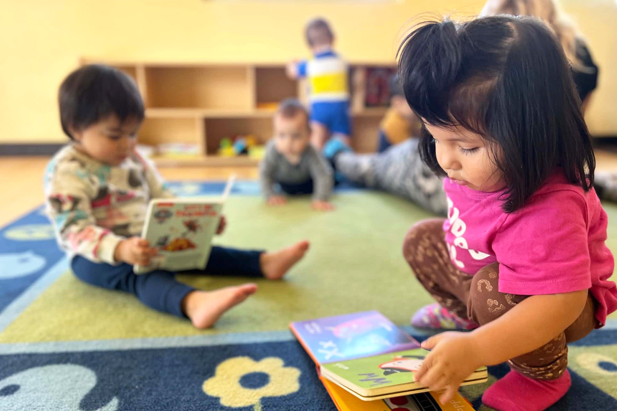 Infant care book reading session with caregiver and baby
